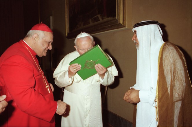 Papież Jan Paweł II w środku całuje Koran, Świętą Księgę Islamu, na zdjęciu zrobionym 14 maja 1999 roku w Watykanie. Chaldejski patriarcha Rafael I Bidawid po lewej. AP Photo / L'Osservatore Romano